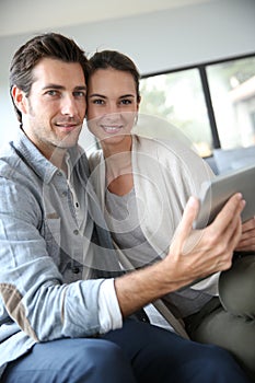 Couple at home websurfing on tablet