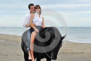 Couple and horse on the beach