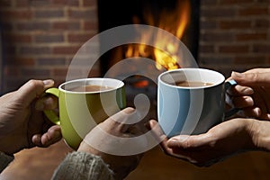 Couple With Hot Drink Relaxing By Fire