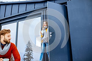 Couple with hot drinks near the house in the mountains