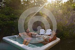 couple in hot tub bath in the rain forest of Vancouver Island, men and women in jacuzzi