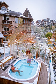 Couple in hot tub during snow in the Canadian rockies in Canada, men and woman in hot tub