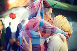 Couple, hug and kiss with love at music festival for bonding, affection or celebration together. Happy, woman and man