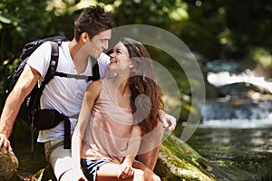 Couple, hug and vacation for hiking in jungle with smile for thinking, holiday and connection by river. Man, woman and