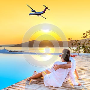 Couple in hug watching airplane at sunset