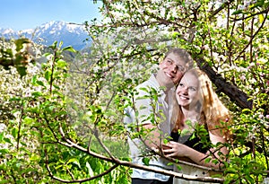 Couple hugging around bloomy trees