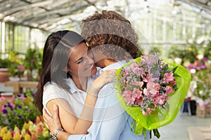 Couple hugging in flower nursery