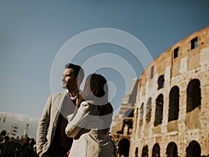 couple hugging in front of Colosseum in Rome, Italy
