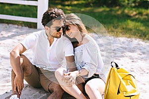 couple hugging and holding hands on sandy