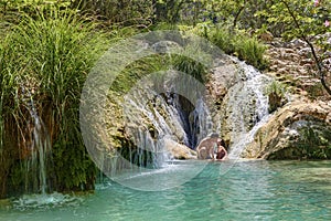 Couple hugging and kissing under waterfall