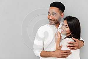 Couple hugging and looking away