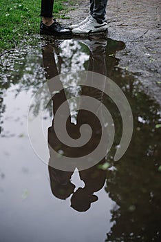 Couple hugging in puddle reflection photo