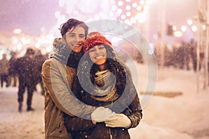 Couple Hugging Smiling At Camera Standing On Christmas Market Outdoor