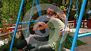 Couple hugging on swing