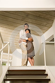 Couple hugging at top of stairs