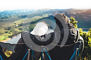 Couple hugging two romantic people cuddling and looking panoramic landscape of sun flare mountain, travelers weekend concept