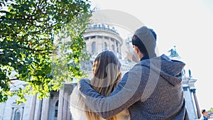 Couple hugs and looks at Cathedral. Concept. Beautiful couple on vacation looking at historical sights of city. Back