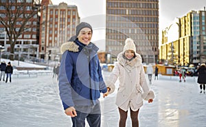 couple ice skating outdoors on a winter day