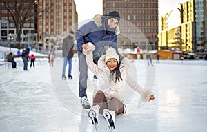 couple ice skating outdoors on a winter day