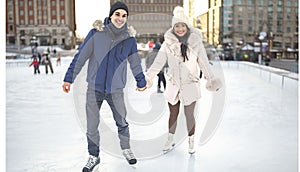 couple ice skating outdoors on a winter day