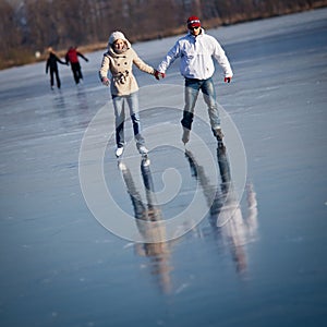 Couple ice skating on a pond