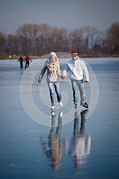 Couple ice skating on a pond