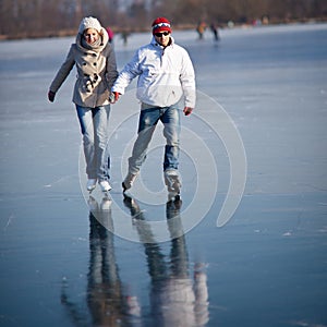 Couple ice skating on a pond