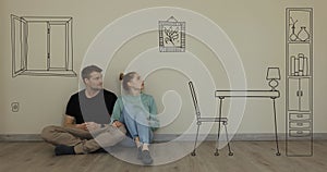 Couple imagine interior of new house. sitting on floor and dreaming in empty room