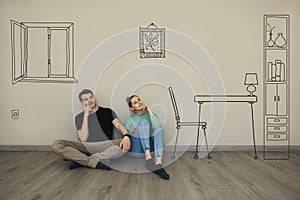 Couple imagine interior of new house. sitting on floor and thinking in empty room