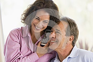 Couple indoors using telephone smiling