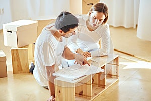 Couple installing furniture in new house with instruction