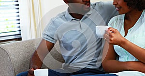 Couple interacting with each other while having coffee in living room 4k