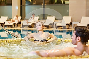 Couple in jacuzzi resting spa center.