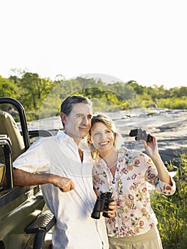 Couple By Jeep With Binoculars