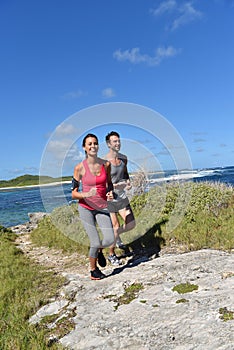 Couple of joggers running on the coastline photo