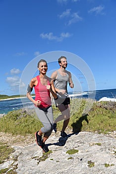 Couple of joggers running on the seaside photo