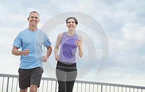 Couple Jogging Against Cloudy Sky