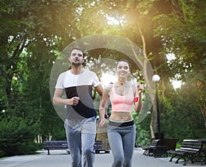 Couple jogging outdoors working out in the park