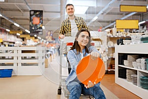 Couple jokes with cart and plate, houseware store