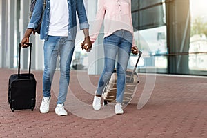 Couple Journey. Unrecognizable Black Lovers Walking With Suitcases Outdoors Near Airport Terminal