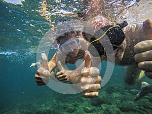 Couple joyfully swimming underwater in sea