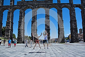 Couple jumping happily in front of roman ruins