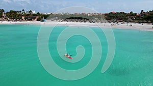 Couple Kayaking in the Ocean on Vacation Aruba Caribbean sea, man and woman mid age kayak in ocean blue clear water