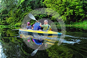 Couple kayaking together in river. Tourists kayakers touring the river