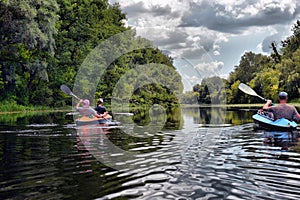 Couple kayaking together in river. Tourists kayakers touring the river