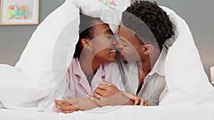 Couple, kiss and love in the bedroom while laughing and feeling happy on their honeymoon. Loving black man and woman