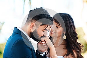 Couple, kiss and wedding ring in outdoors, hand and symbol for promise of loyalty or commitment. People, celebration and