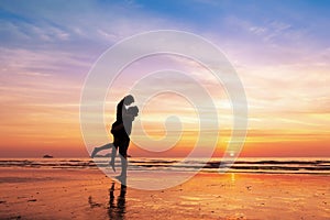Couple kissing on the beach with beautiful sunset in background