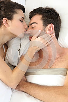 Couple kissing in bed