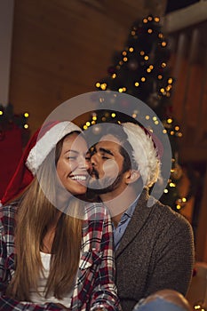 Couple kissing by the Christmas tree